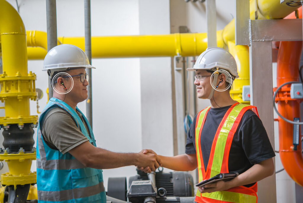 Two engineers shaking hand in the boiler room,maintenance checki